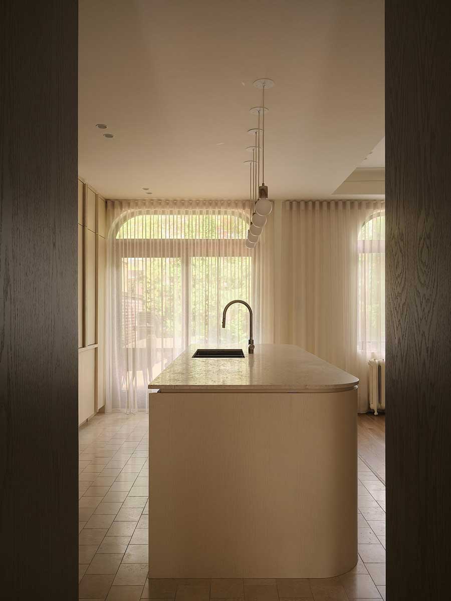 Kuchyňský ostrůvek s oblými hranami a světlou pracovní deskou v otevřeném prostoru