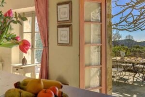 Pohled z kuchyňského pultu ve vile Brigitte Bardot směrem na terasu a zahradu na Francouzské riviéře.