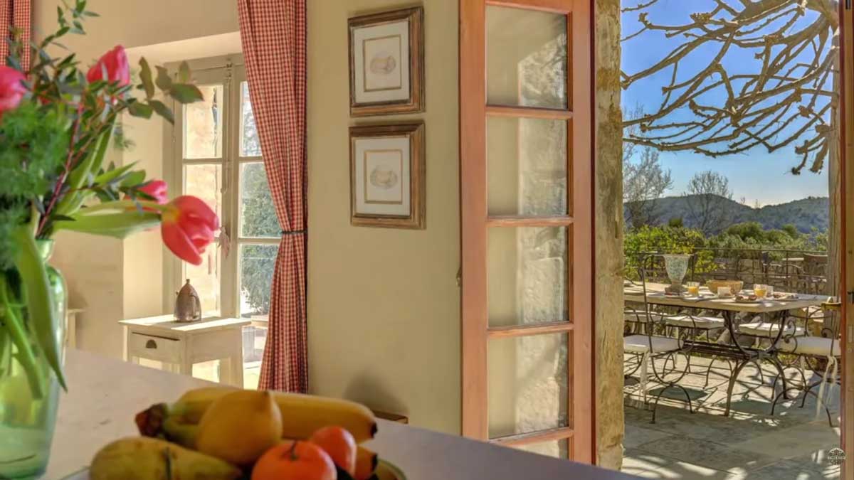 Pohled z kuchyňského pultu ve vile Brigitte Bardot směrem na terasu a zahradu na Francouzské riviéře.