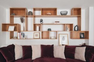 Sametová pohovka v sytém tónu vytváří kontrast k čistým liniím modernistického interiéru