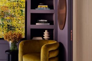 Sametové křeslo v tlumeném odstínu zelené jako výrazný solitér v moderním interiéru