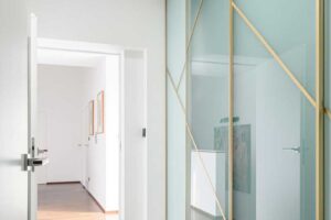 Vestavěná šatní skříň s otevřeným sezením a integrovaným osvětlením v předsíni.