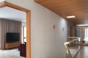 Schodiště s dřevěným obkladem a subtilním zábradlím podtrhuje architektonickou čistotu domu.