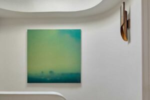 Schodiště s oblými liniemi doplněné obrazem a střešním světlíkem