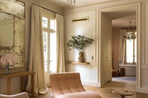 Společenská zóna se světlou sedačkou, historickými prvky a výhledem do parku