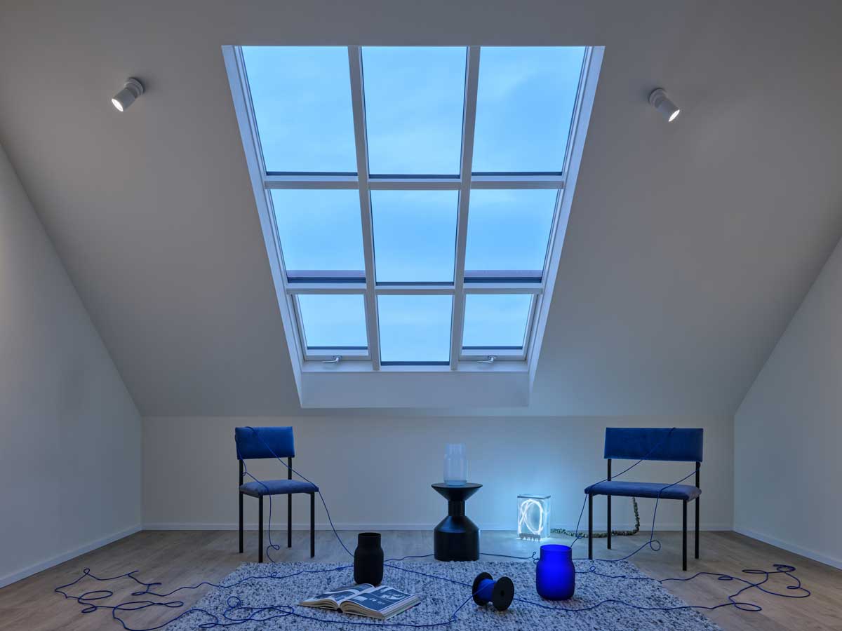 Podkrovní interiér s velkorysými střešními okny zajišťujícími dostatek denního světla