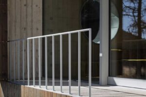 Terasa u stodoly s dřevěným obkladem betonovou podezdívkou a zábradlím