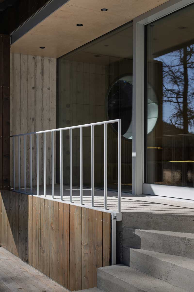 Terasa u stodoly s dřevěným obkladem betonovou podezdívkou a zábradlím