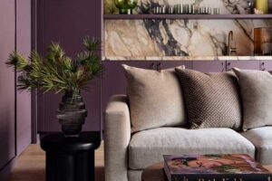 Denní zóna v tlumených tónech s pohodlnou pohovkou a mramorovým obkladem