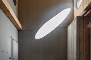 Vestavěné úložné prostory v podkroví s vláknocementovými deskami a přiznanou konstrukcí