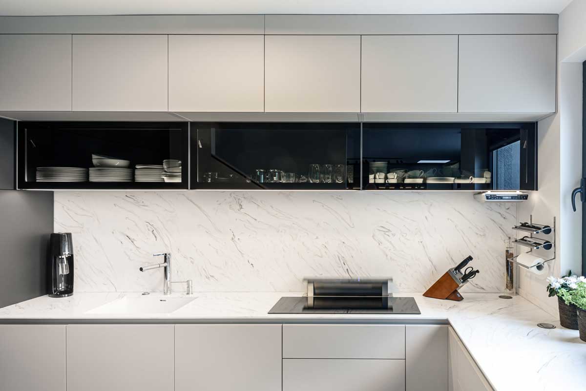 Kuchyňská sestava s horními skříňkami, otevřenými policemi a integrovaným osvětlením.