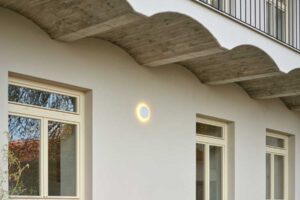 Vnitroblok pavlačového domu s předzahrádkami přízemních bytů a společným posezením