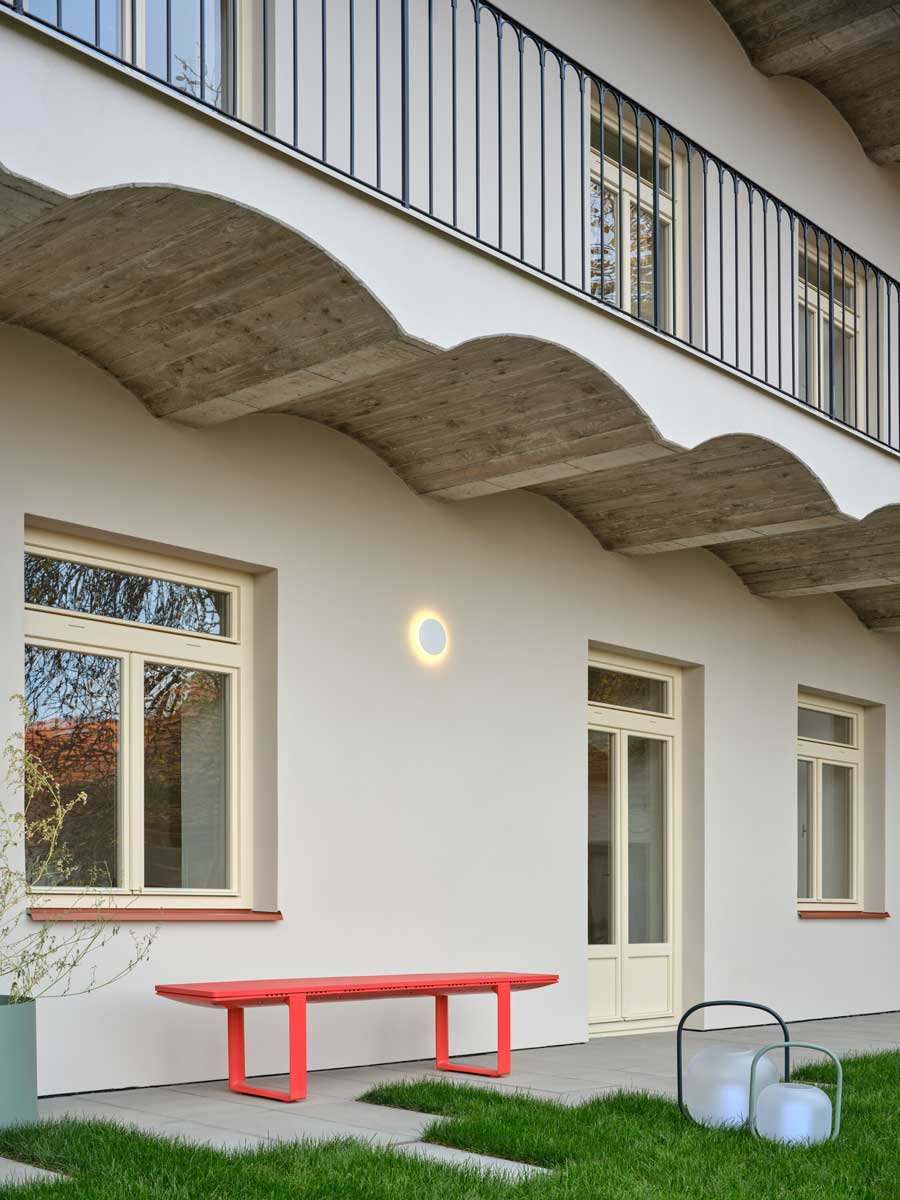 Vnitroblok pavlačového domu s předzahrádkami přízemních bytů a společným posezením