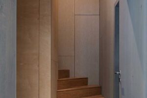 Vstup ke schodišti s dřevěnými stupni a vestavěnými stěnami