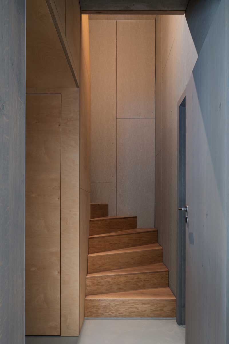 Vstup ke schodišti s dřevěnými stupni a vestavěnými stěnami