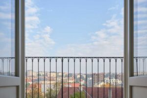 Výhled z pavlače rekonstruovaného domu v Nuslích s keramickou dlažbou a kovovým zábradlím