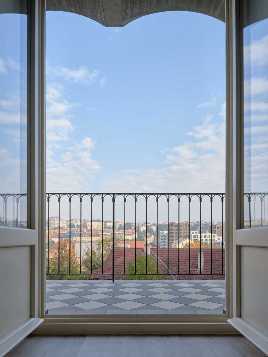 Výhled z pavlače rekonstruovaného domu v Nuslích s keramickou dlažbou a kovovým zábradlím