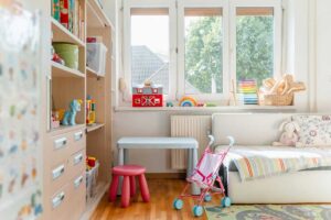 Dětský pokoj s nábytkem umístěným před radiátorem který brání proudění tepla v místnosti