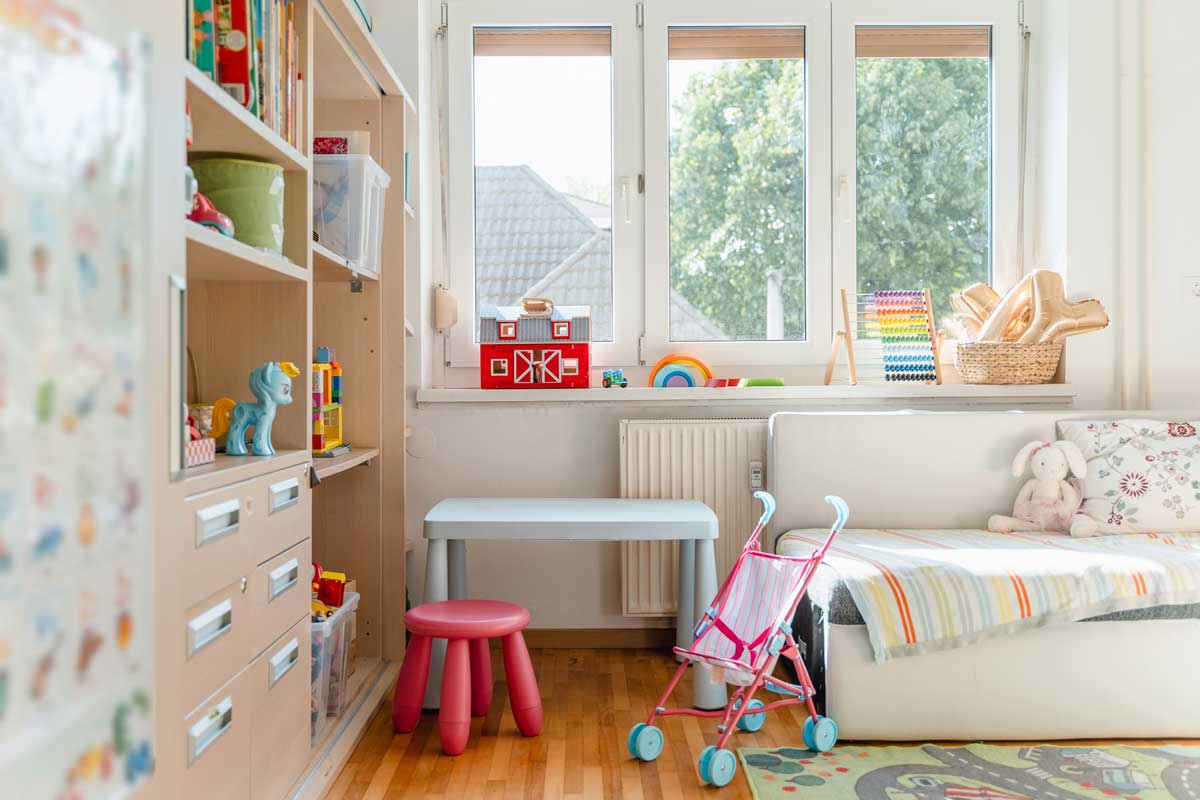 Dětský pokoj s nábytkem umístěným před radiátorem který brání proudění tepla v místnosti