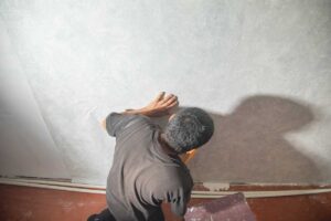 Aplikace betonové stěrky na stěnu vytváří industriální atmosféru bez nutnosti stavebních úprav.