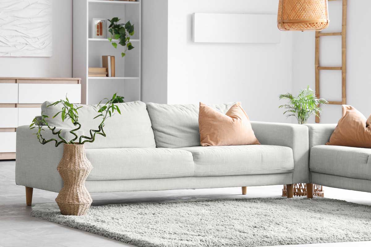 Bílá pohovka v jemném neutrálním odstínu jako ukázka uklidňujícího nábytku inspirovaného barvou roku.