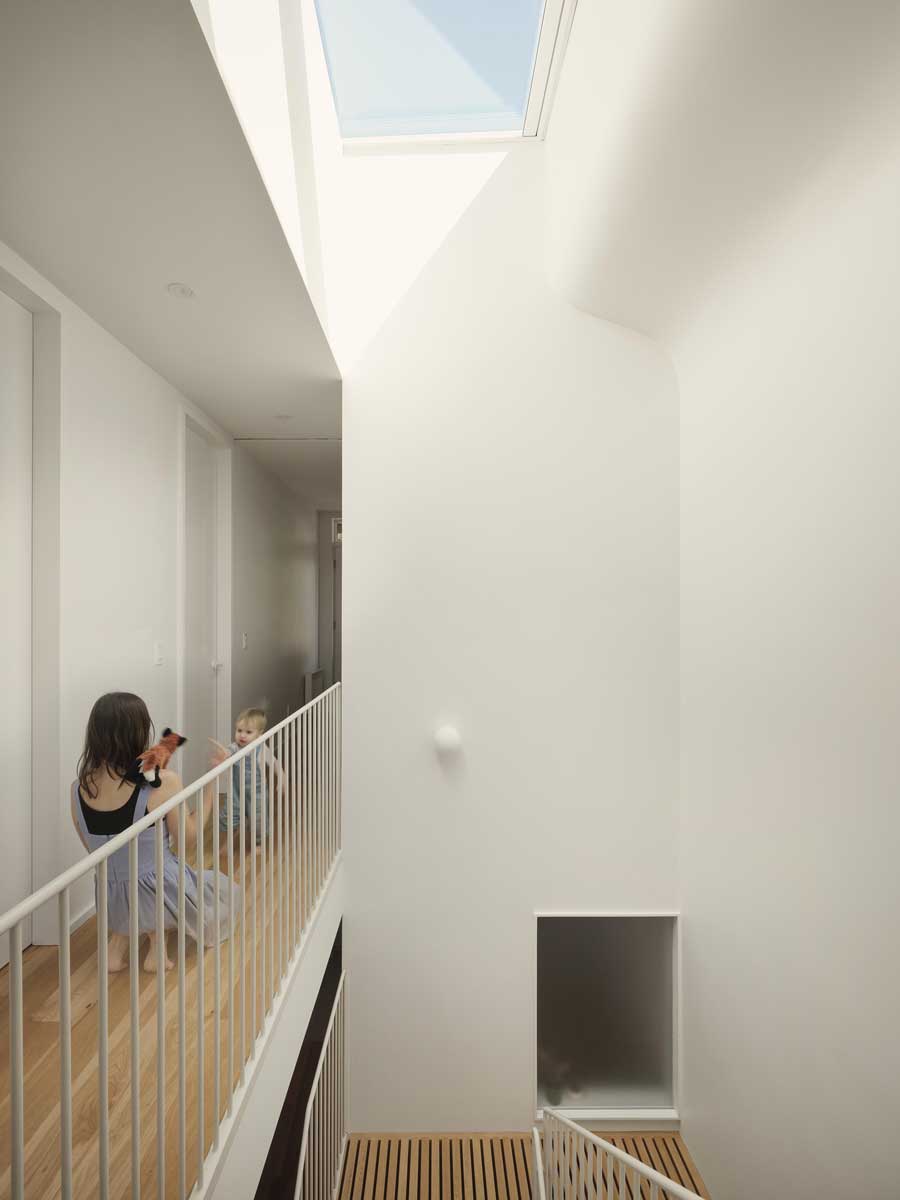 Chodba v patře prosvětlená střešním světlíkem nad schodištěm.