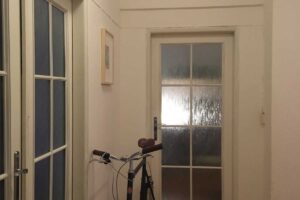 Původní úzká chodba s tmavým interiérem před rekonstrukcí bytu