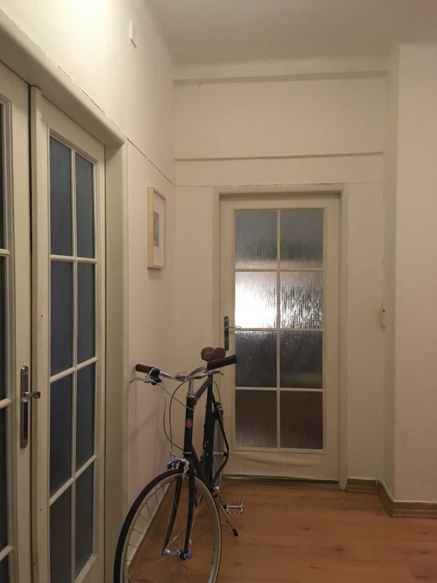 Původní úzká chodba s tmavým interiérem před rekonstrukcí bytu