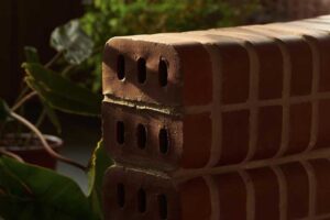 Nízká zakřivená cihlová zídka funguje jako lavička i přirozená hranice mezi jednotlivými zónami bytu.