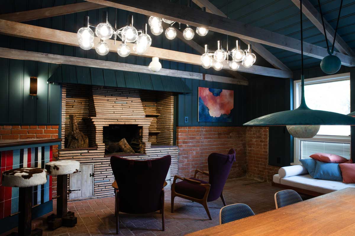 Denní obytná zóna s krbem, výraznými barvami a otevřeným uspořádáním propojuje společné chvíle s klidem a pohodou.