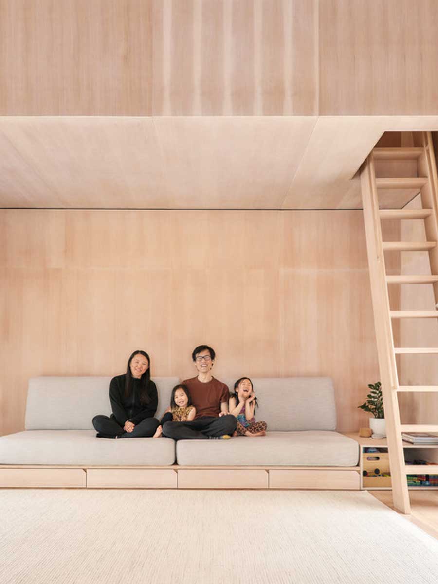 Centrální obytný prostor ze světlého dřeva nabízí vestavěné sezení a úložné prostory pod lavicí.