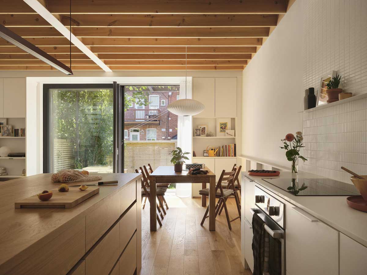 Jídelna a kuchyň otevřené do zahrady s velkým prosklením orientovaným na jihozápad.