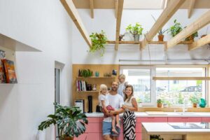 Kuchyně v dřevostavbě s kombinací fasádního a střešního okna pro přirozené osvětlení pracovní plochy