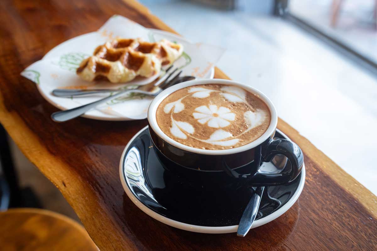 Šálek cappuccina s latte art podávaný jako domácí káva ve stylu baristy