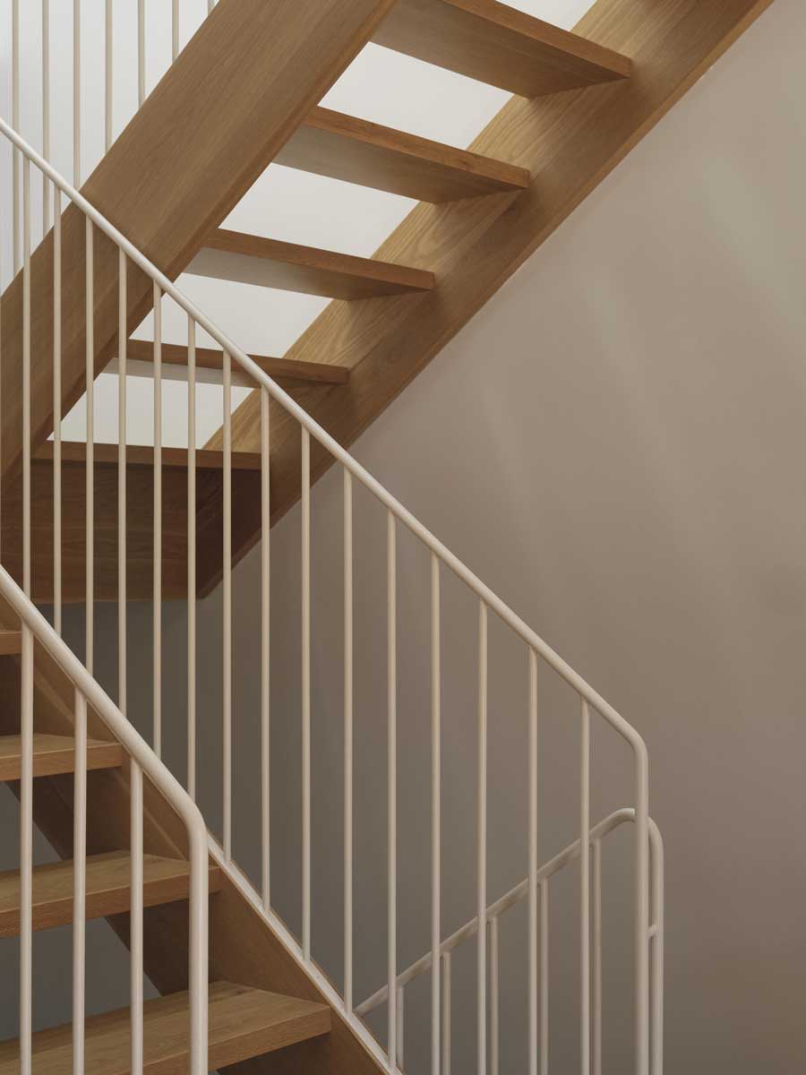 Detail schodiště z bílého dubu s jednoduchým bílým zábradlím v Lilac House.