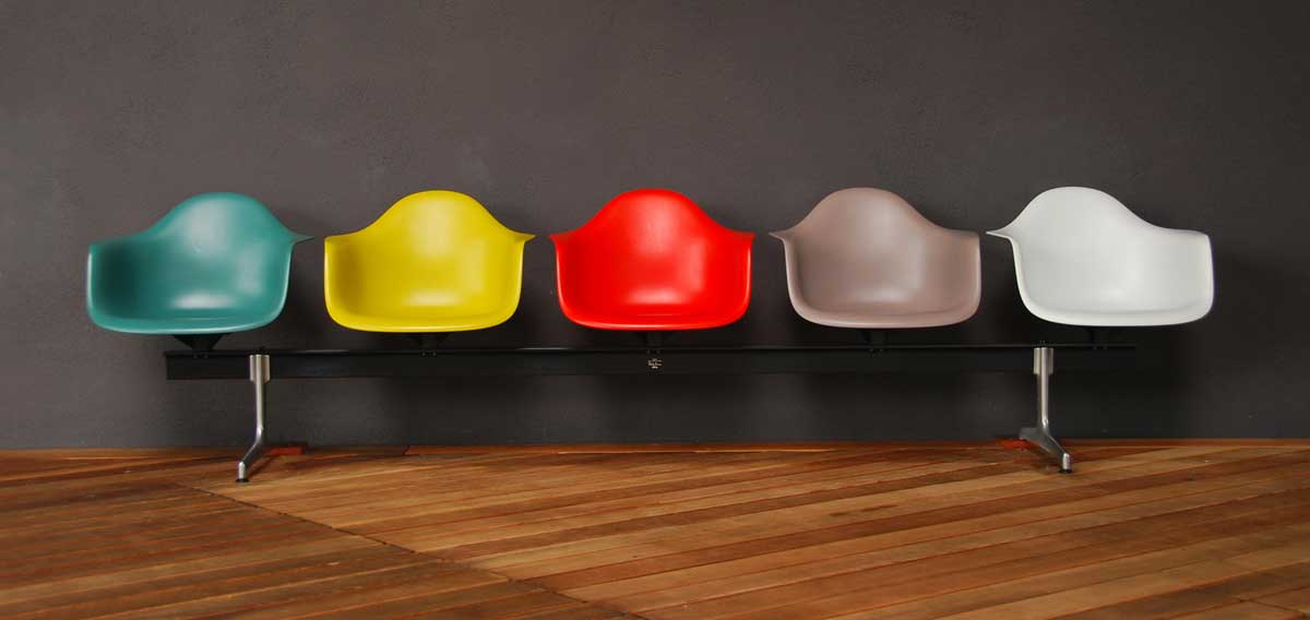 Barevné plastové židle Eames Shell Chair v různých odstínech, první průmyslově vyráběná plastová židle navržená pro každodenní použití
