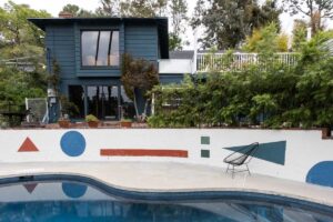 Exteriér domu Zappa Nest s bazénem a geometrickými motivy plynule navazuje na hravý a barevný interiér.