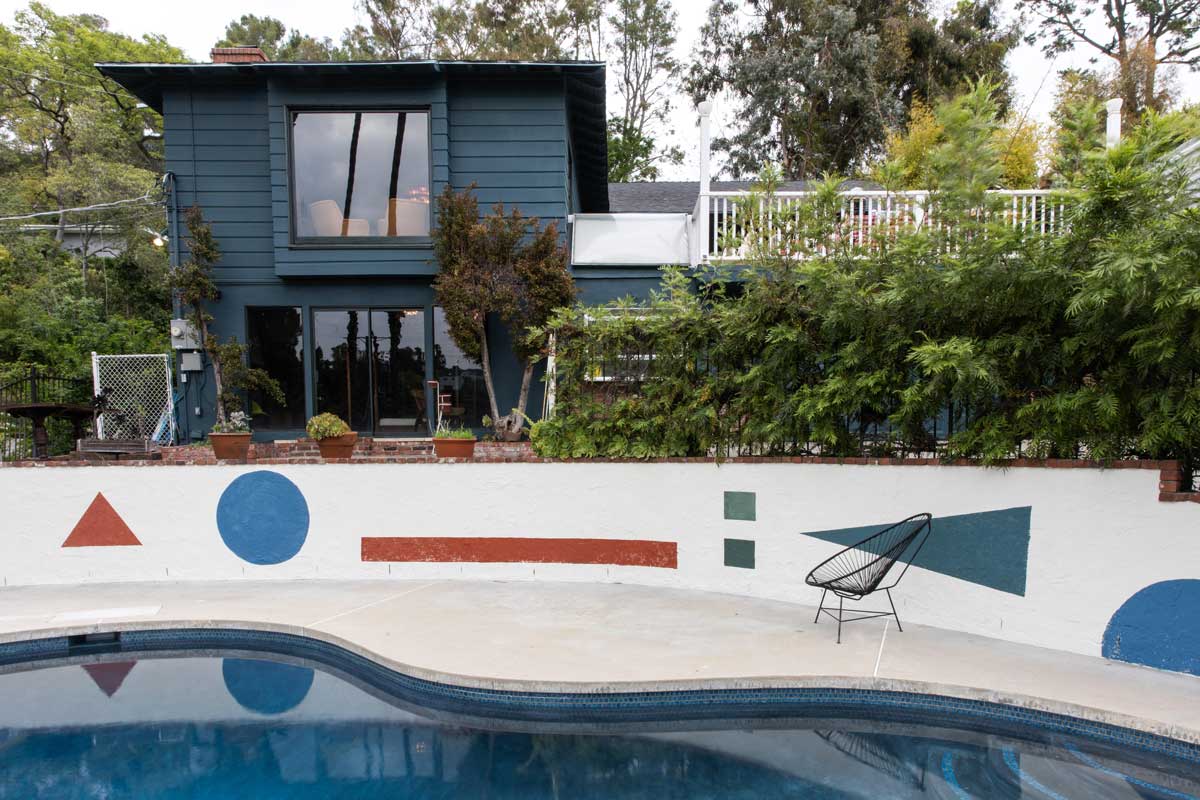 Exteriér domu Zappa Nest s bazénem a geometrickými motivy plynule navazuje na hravý a barevný interiér.