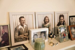 Rámečky s rodinnými fotografiemi opřené o stěnu na komodě vytvářejí osobní atmosféru bez nutnosti vrtání do zdi.