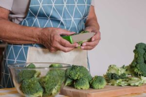 Krácení brokolice na kuchyňské pracovní desce ve výšce odpovídající pravidlu lokte