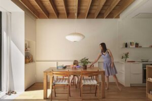 Jídelní kout s masivním stolem pod dřevěným stropem a výhledem do zahrady.