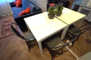 Jídelní stůl se zrcadlovou stěnou v malé garsonce, který opticky zvětšuje prostor