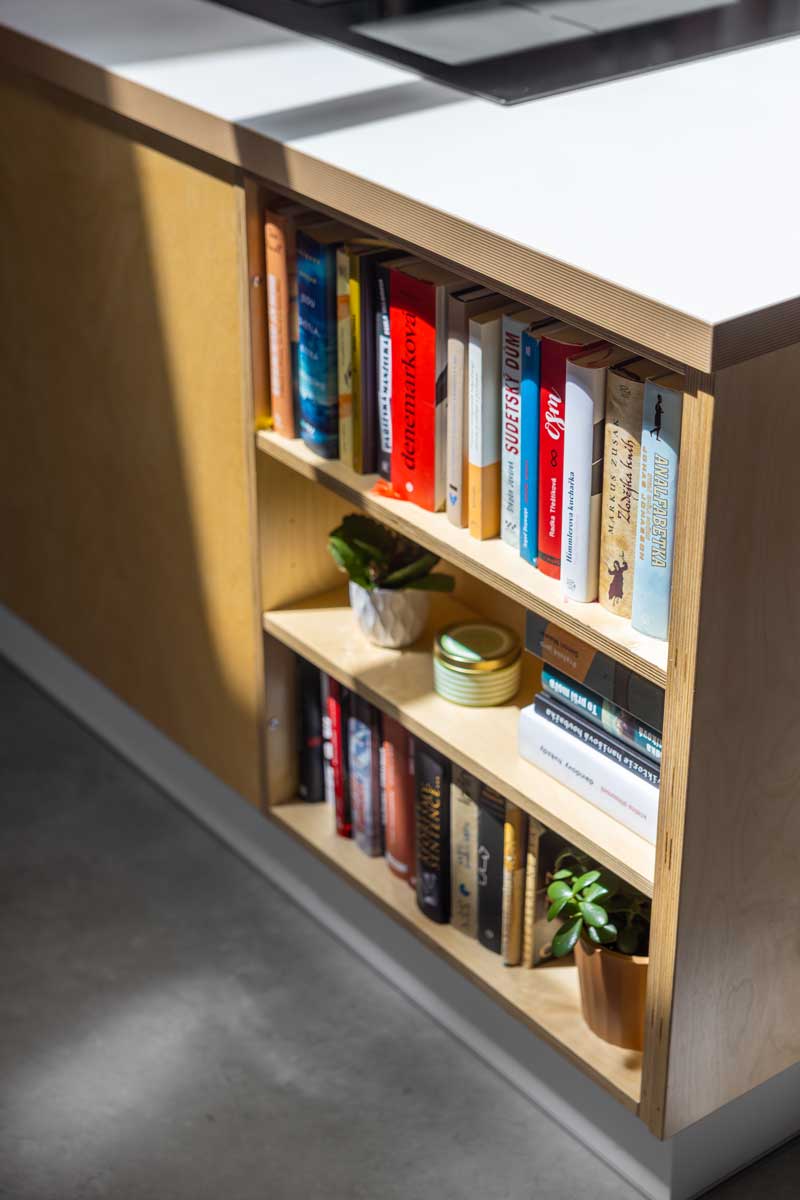 Vestavná knihovna v kuchyňském ostrůvku nízkoenergetické dřevostavby ze světlé překližky