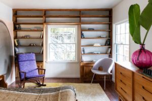 Ložnice s vestavěnou dřevěnou knihovnou propojuje klidový prostor s osobními předměty a místy pro tiché rozjímání.