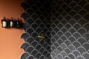 Koupelna s výrazným obkladem a kontrastní barevností působí intimně a podporuje smyslový zážitek z prostoru.