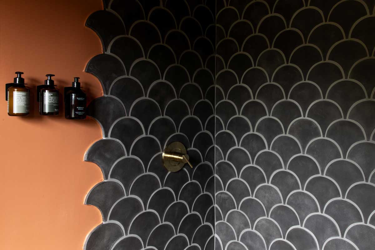 Koupelna s výrazným obkladem a kontrastní barevností působí intimně a podporuje smyslový zážitek z prostoru.