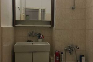 Původní koupelna s vanou a obklady v neutrálních tónech před rekonstrukcí bytu