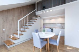 Moderní byt s galerií a otevřeným schodištěm působí vzdušně díky jednotné podlaze a světlým barvám.