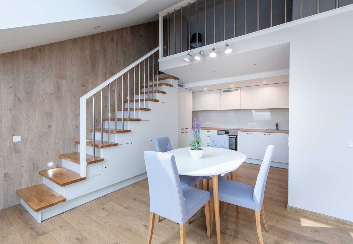 Moderní byt s galerií a otevřeným schodištěm působí vzdušně díky jednotné podlaze a světlým barvám.