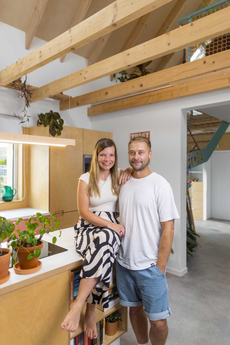 Majitelé nízkoenergetické dřevostavby ve své otevřené kuchyni s přiznanou dřevěnou konstrukcí